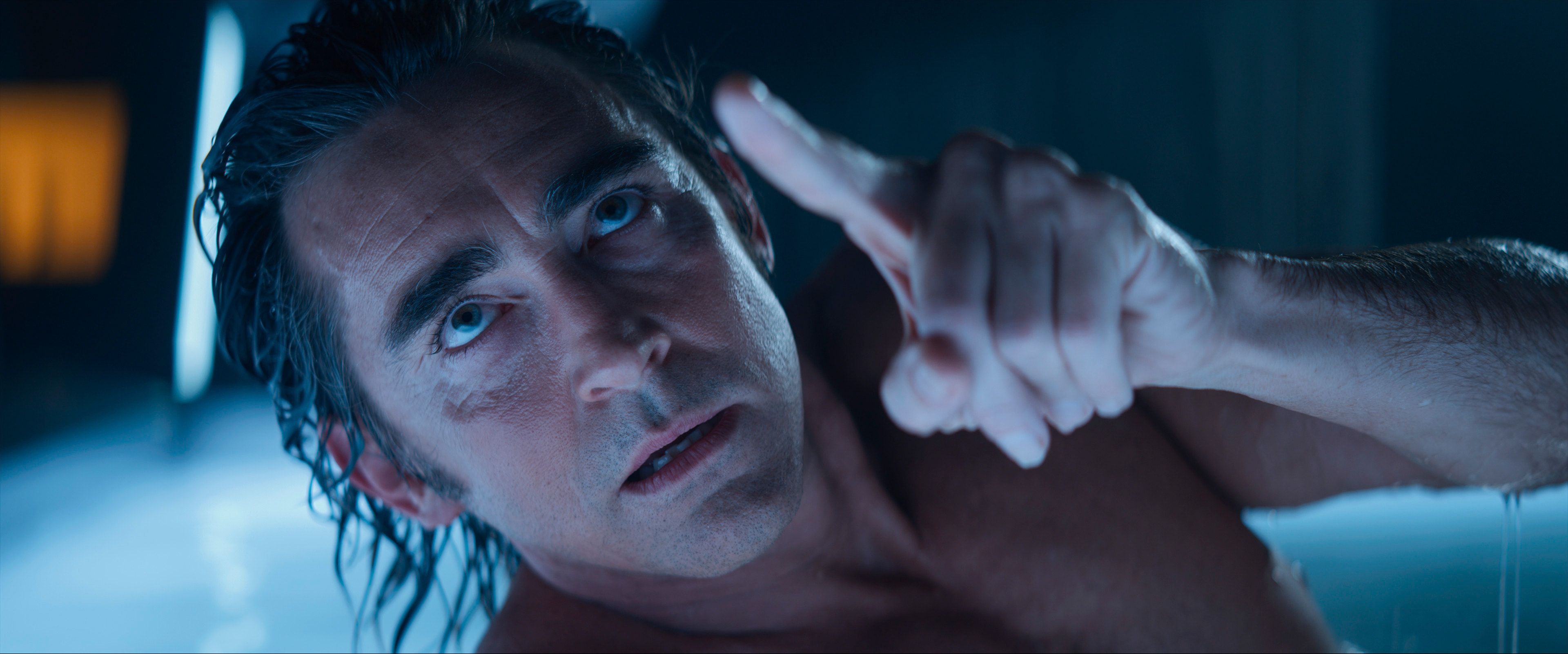 Lee Pace, naked and bathed in blue light, sitting up and looking toward the camera in Apple TV Plus’ Foundation 