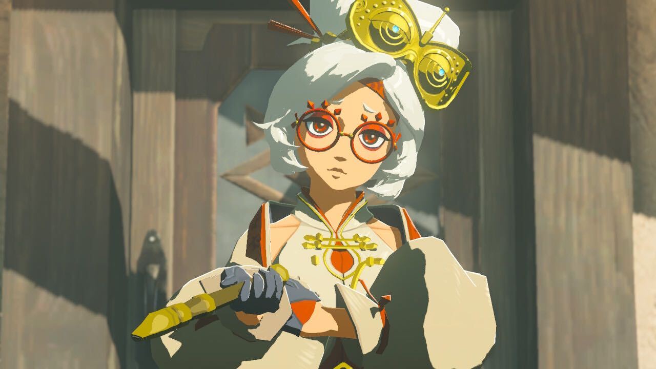 An image of Purah from The Legend of Zelda: Tears of the Kingdom. She wears her hair in a big bun on top of her head. She’s looking inquisitively into the camera.