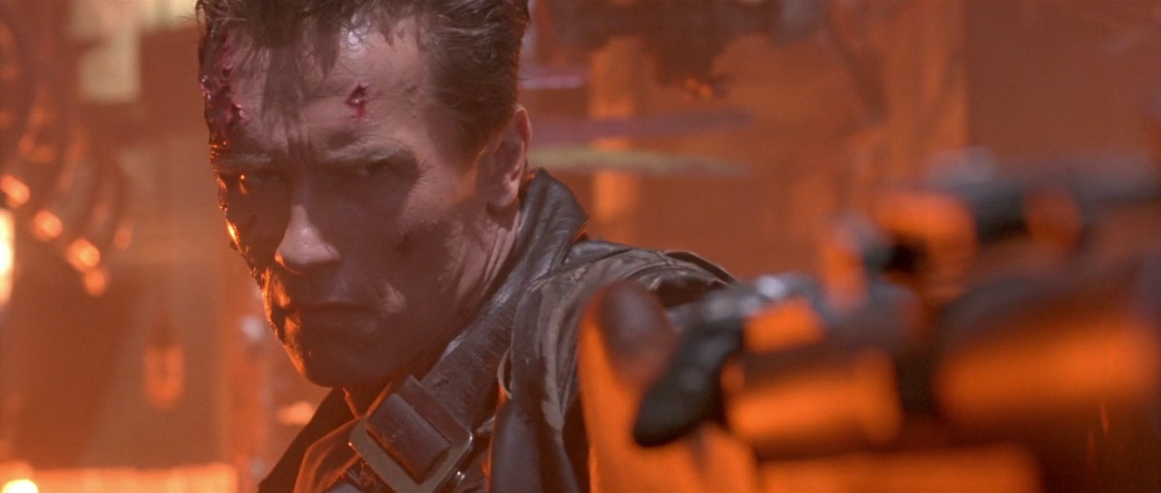 Close-up shot of Arnold Schwarzenegger as a reprogrammed “T-800” cyborg aiming a grenade gun in Terminator 2: Judgement Day.