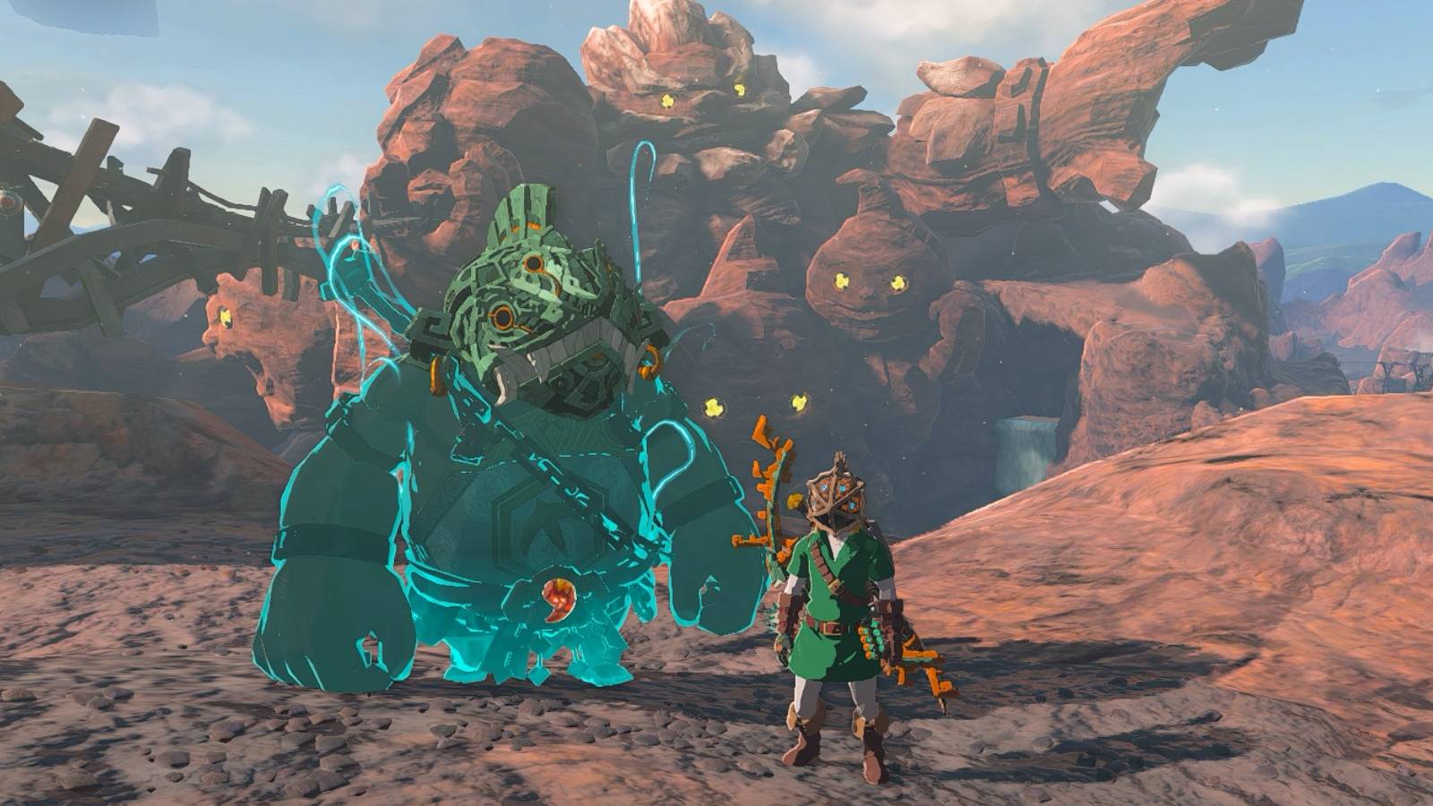 Link and Yunobo wearing the Vah Rudania Divine Helm in front of the Goron Mt Rushmore in Zelda: Tears of the Kingdom.